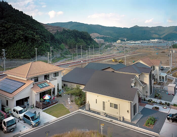 女川町鷲神（2015年）。造成が完了し住宅が建ち始めた夏に、高台の駐車場から撮影を終えると、一組の夫婦が振り返り手を振った。新たな生活の始まりを象徴する一場面だった