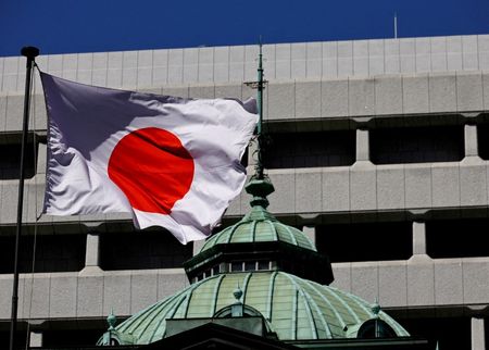 　２月１９日、日銀の高田創審議委員は宮城県金融経済懇談会後の記者会見で、次回の利上げまでの期間や政策金利の最終的な到達点について「予断を持って対応をすることではない」と述べた。写真は日銀の建物と日本国旗で、２０２４年３月都内で撮影（２０２５年　ロイター／Kim Kyung-Hoon）