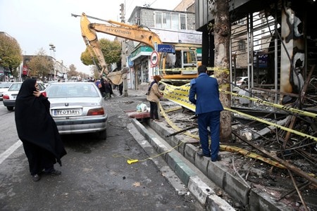 １１月２７日、イランの最高指導者ハメネイ師は、約２週間続く反政府デモについて、「極めて危険な陰謀」によるものだと主張したうえで、デモを完全に鎮圧したと明らかにした。写真はテヘランで２０日、放火された銀行の前を歩く人々（２０１９年　ロイター/Nazanin Tabatabaee)