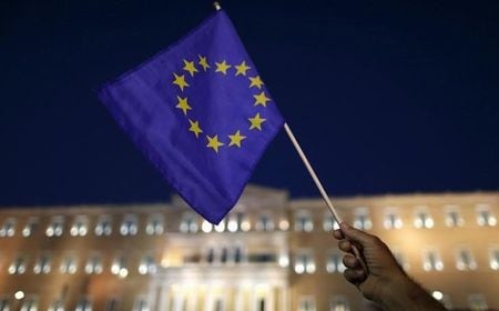 　８月１４日、ユーログループは、ギリシャへの第３次支援実施で合意した。写真はＥＵ旗を手にする人。アテネで７月撮影（２０１５年　ロイター／Christian Hartmann）