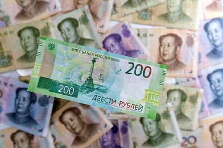 ７月６日、 中国は主要国・地域の中で唯一、今年の経済成長持ち直しが期待できるという点で、外国人投資家を引きつけている。写真は人民元とロシア・ルーブル紙幣。５月撮影（２０２２年　ロイター/Dado Ruvic）