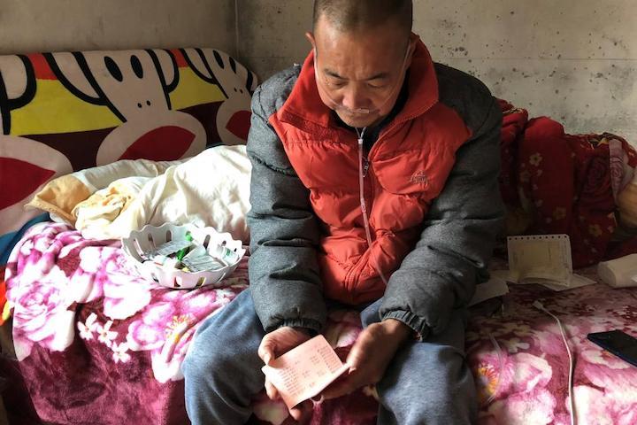 12月14日、2000年前後の4年間、中国深センで解体作業員として働いていたWang Zhaohongさん（写真）は、かつて国境沿いの寒村だったこの街を、活気あふれる大都市に変貌させたこの仕事が自分の命を奪うことになると語った。中国湖南省桑植県の自宅のベッドの上で取材に応じるWangさん。11月撮影（2018年　ロイター/Sue-Lin Wong）