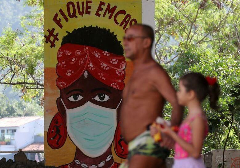 ブラジル政府が新型コロナウイルスの感染者数と死亡者数について矛盾するデータを公表したことから、議会が批判を強め、真相究明のための調査を求める声が出てきた。写真はリオデジャネイロを歩く男性と子ども(2020年　ロイター/Sergio Moraes)