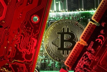 　１２月７日、スロベニアに拠点を置く仮想通貨のマーケットプレイス「ナイスハッシュ」は、セキュリティーの侵害によりウォレット（保管所）からビットコインが盗まれたと明らかにした。幹部によると、被害は時価にして６４００万ドル相当に上るという。写真はビットコインのレプリカとマザーボード。１０月撮影（２０１７年　ロイター／Dado Ruvic）