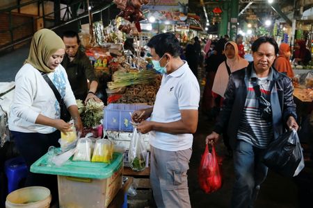 　２月１日、インドネシア統計局が発表した１月の消費者物価指数（ＣＰＩ）上昇率は前年比５．２８％で、５カ月ぶりの低水準だった。中央銀行の目標レンジ（２─４％）は上回った。写真は市場で買い物をする人々。インドネシアのデポックで昨年６月撮影（２０２３年　ロイター／Ajeng Dinar Ulfiana）