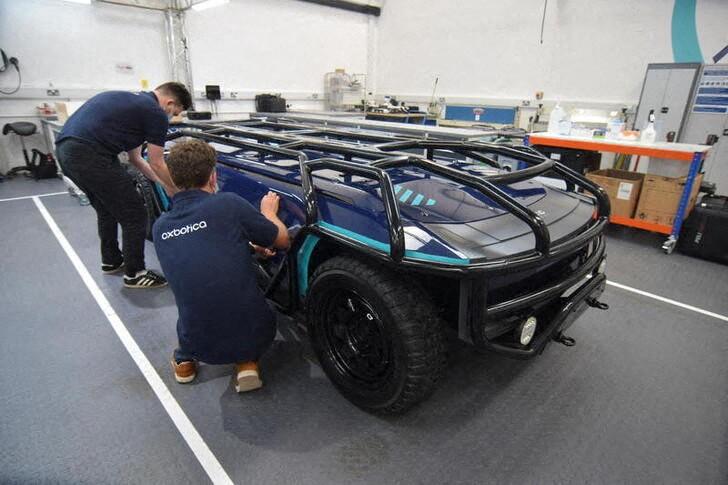 完全な自動運転による乗用車はスタートを切るにも苦労しており、投資家の中には、ドライバー抜きのトラックの方が最初にゴールにたどり着く方に賭けようという動きも見られる。写真は10月、アプライドEVが開発した用途特化型の完全電動による自動運転車を使って作業する、オクスボティカの従業員。英オックスフォードで撮影（2021年　ロイター／Nick Carey）