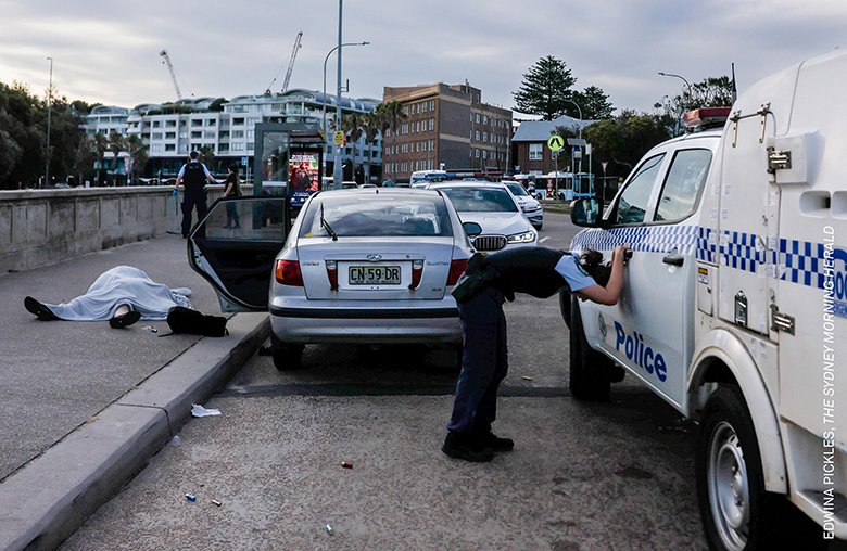 「単写真（アジア太平洋・オセアニア）」部門 『ボンダイビーチのテロ』 »Edwina Pickles　昨年12月14日、オーストラリア・シドニーのボンダイビーチで起きた銃乱射現場で、夫婦の遺体のそばで動揺する警察官。15人が殺害された事件はユダヤ教の祝祭ハヌカを狙ったもので、過激派組織「イスラム国」（IS）の思想に感化された父子の犯行だった