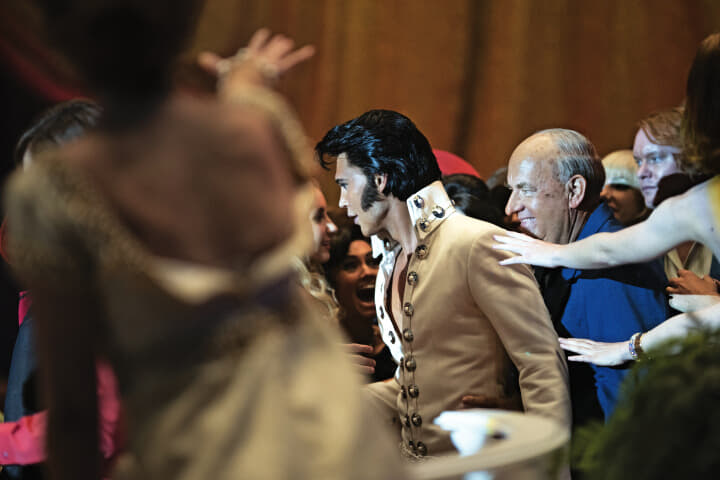 世界の目がプレスリー（オースティン・バトラー）に集まるなか、パーカー（ハンクス）はいつも目立たない場所にいた　COURTESY OF WARNER BROS. PICTURES