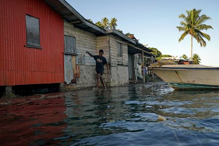 ９月２０日、過去の記録を塗り替える猛暑に加え、壊滅的な暴風雨や洪水が各地で発生した２０２３年の異常気象は、気候変動対策の緊急性を浮き彫りにしている。写真は海面上昇により、浸水被害を受けるようになったフィジーの村。２０２２年７月撮影（２０２３年　ロイター/Loren Elliott）
