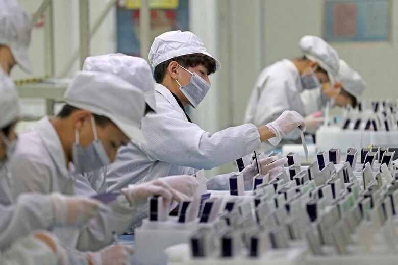 太陽光発電部品の製造ラインで作業する従業員。2019年2月、中国・浙江省湖州市の工場で撮影。Zhejiang Daily提供。REUTERS