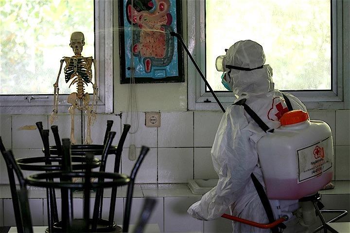 感染の影響で休校となったジャカルタ市内の学校をボランティアが消毒している。Willy Kurniawan - REUTERS
