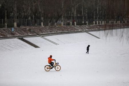 　２月１６日、中国北京市は、就学前の選択教科の個人指導アプリを禁止する草案を公表した。写真は昨年１月、凍った川の上で自転車に乗る子ども。北京で撮影（２０２２年　ロイター／Tingshu Wang）