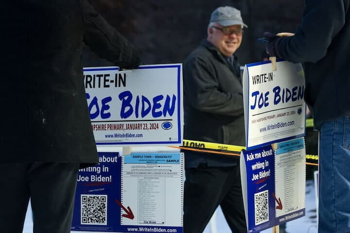 １月２３日、バイデン米大統領は２３日にニューハンプシャー州で行われた民主党予備選で、投票用紙に名前の記載がなかったにもかかわらず勝利を確実にした。写真は投票者に対してバイデン氏の名を書くよう呼びかける人々。ニューハンプシャー州で撮影（２０２４　ロイター／Reba Saldanha）
