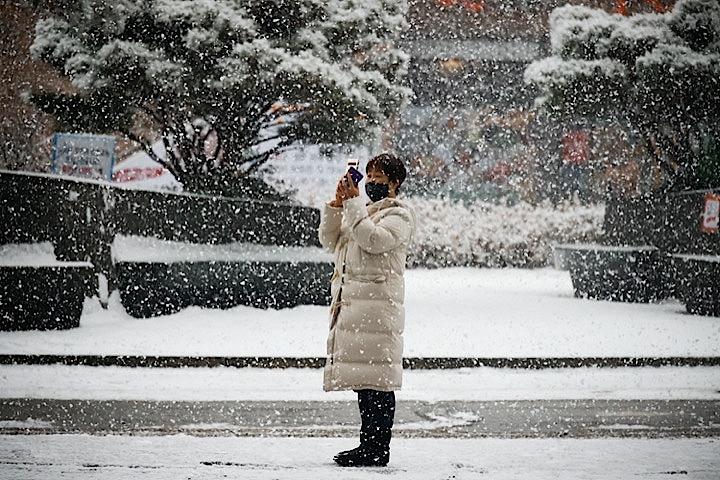 1月12日、寒波に襲われた韓国ではホームショッピングでロングダウンコートが飛ぶように売れた。写真は12日、ソウル中心部で撮影。REUTERS/Kim Hong-Ji