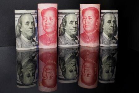 　８月１７日、中国の主要国有銀行は今週、人民元の急速な下落を食い止めるため、オンショアとオフショアのスポット市場でドル売り・元買いに奔走したもようだ。写真は中国元と米ドルの紙幣。北京で昨年９月撮影（２０２３年　ロイター／Florence Lo）