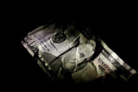 　８月１７日、ゴールドマン・サックスのエコノミストチームは、今年に入ってからのドルの幅広い下落について、米国の７月から来年末までのコア物価上昇率を小幅にしか押し上げないと予想。写真は米ドル紙幣。６月撮影（２０１７年　ロイター/Thomas White）