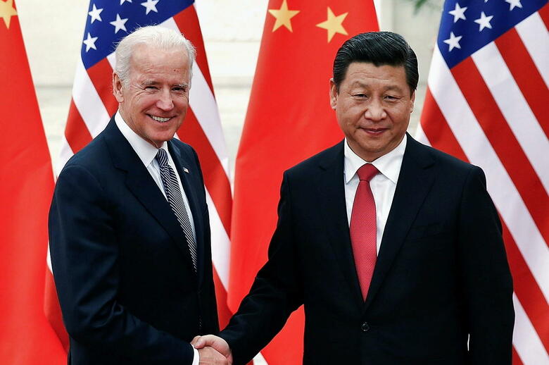 2013年12月、訪中したバイデン副大統領（当時）と握手する習近平国家主席　Lintao Zhang-REUTERS