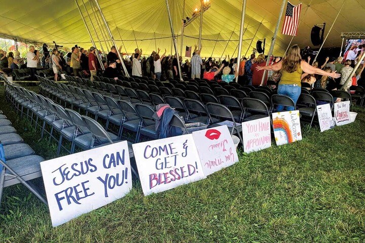 新カリスマ運動の集会で指導者たちの話に耳を傾ける福音派の信者ら