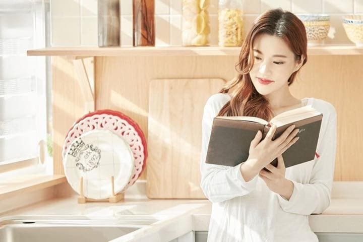 キッチンで読書する女性