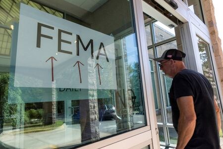 　米連邦緊急事態管理局（ＦＥＭＡ）のキャメロン・ハミルトン局長代行がＦＥＭＡ廃止に反対する議会証言を行った翌日に解任されたことについて、証言前から解任の動きがあり、同氏も解任を予期していたことが関係者の話で明らかになった。写真は、ハリケーンによる洪水で被害を受けた地元民がFEMAの仮設ステーションに入る様子。２０２４年１０月、ノースカロライナのマリオンで撮影（２０２５年　ロイター/Eduardo Munoz）