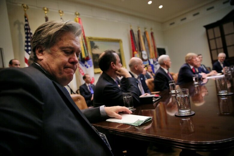 １月４日、トランプ米大統領が個人で契約している弁護士は、コラムニストのマイケル・ウォルフ氏が執筆した政権の暴露本について、ウォルフ氏と出版社に出版差し止めを求めることもあり得ると通告した。写真は元側近スティーブ・バノン氏（手前）ら。ホワイトハウスで２０１７年２月撮影（２０１８年　ロイター/Carlos Barria）