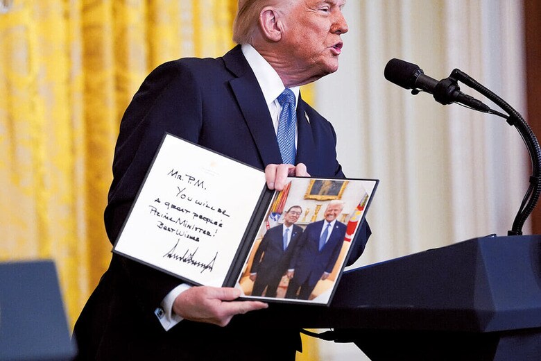 共同記者会見で石破と2人で撮った写真を見せるトランプ（2月7日）　KENT NISHIMURA–REUTERS