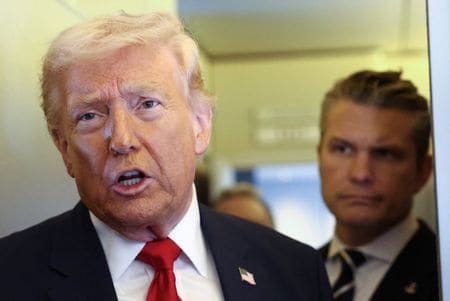 　トランプ米大統領は、イラン南部の女子学校で多数が死亡した攻撃について、証拠に言及せずにイランに責任があるという見解を示した。写真は米デラウェア州ドーバーからフロリダ州マイアミに向かう大統領専用機内で記者団に語るトランプ氏。後ろはヘグセス国防長官。７日撮影（２０２６年　ロイター/Kevin Lamarque）
