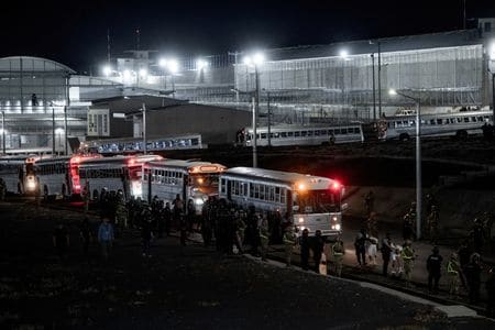 ３月２５日、トランプ米政権は「敵性外国人法」に基づいてベネズエラ人を強制送還した問題で、差し止めを求めた判事の命令に違反していないと改めて主張した。写真は米国から強制送還されたベネズエラの犯罪組織「トレン・デ・アラグア」のメンバーを連行するエルサルバドル当局。１６日撮影、提供写真（２０２５年　ロイター）