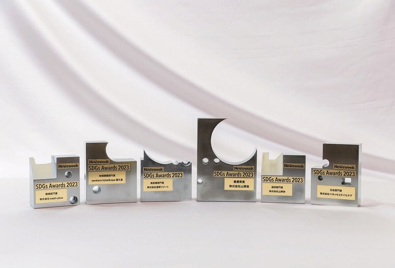 受賞者に授与されたトロフィー。「中川運河学習室」に参加する株式会社近藤印刷、アルプススチール株式会社という名古屋の2社の協力を得て、工場で使われなくなった金型を再利用して制作した特別な「アップサイクル」トロフィーだ。デザインは、グラフィックデザイナーとして名高い京都芸術大学の久保雅由准教授による　PHOTOGRAPH BY HIROSHI ENDO