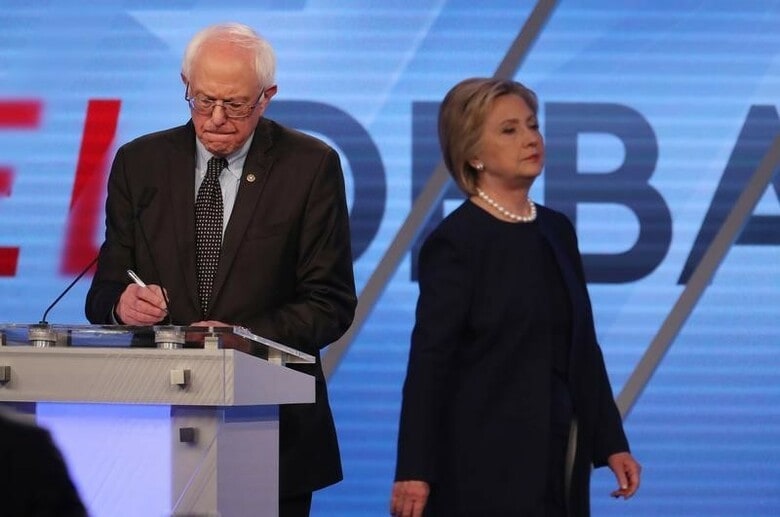 ３月９日、米民主党の大統領候補指名争いは、８日に行われたミシガン州の予備選でヒラリー・クリントン前国務長官がバーニー・サンダース上院議員に予想外の敗北を喫する事態が起きた。写真はクリントン氏（右）とサンダース上院議員。フロリダ州で撮影（２０１６年　ロイター／Carlo Allegri）