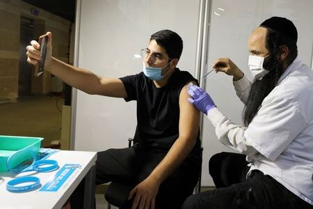　２月２６日、イスラエルのエーデルシュタイン保健相は、少なくとも１回の新型コロナウイルスワクチンの接種を受けた人が人口の５０％に達し、２回の接種完了も３５％となったことを明らかにした。写真はエルサレムのスポーツアリーナで２５日撮影（２０２１年　ロイター/Ammar Awad）