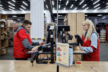 ウクライナのチェルニヒウにある店舗で業務に当たる配送会社ノバポストの従業員。2025年11月撮影。REUTERS/Alina Smutko