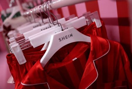 　６月９日、中国発のインターネット通販のＳｈｅｉｎ（シーイン）がインドで財閥リライアンス・インダストリーズと組みサプライヤーを急速に拡充している。写真はシーインのロゴが入ったハンガー。２０２４年１２月、英リバプールで撮影（２０２５年　ロイター/Phil Noble）
