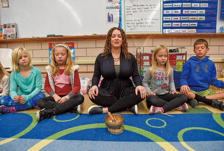 コロラド州デンバーの学校で教師と瞑想に励む子供たち　Andy Cross-The Denver Post/GETTY IMAGES