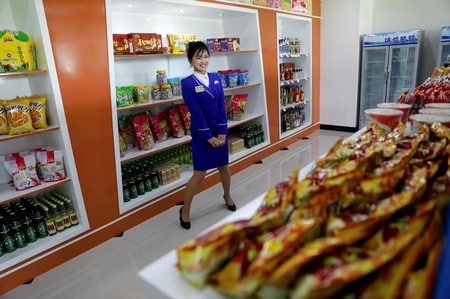 　５月８日、北朝鮮への追加制裁が迫るなか、同国を訪れた人たちの大半は、中国からの輸入品に取って代わる「メイド・イン・北朝鮮」製品を、以前より多く目にすると語る。写真は首都平壌にある食料品店の店員。４月撮影（２０１７年　ロイター/Damir Sagolj）