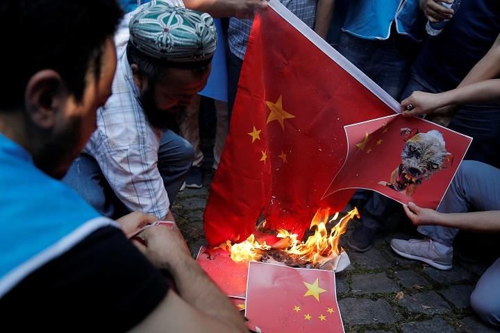 トルコのイスタンブールで行われた反中デモで、中国の国旗を焼くウイグル人（10月1日） Huseyin Aldemir ｰREUTERS