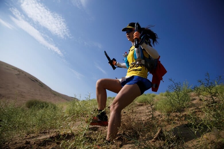 ８月３１日、中国西部の青梅省からチベットに広がる高地は夜明けを迎え、サフラン色の服に身を包んだ仏教の僧侶が、１００キロ走のスタートを前に体を動かすアスリートたちに祝福の言葉をかけていた。写真は８月１１日、青海省の野を走るスーパーサーモン・ウルトラマラソンの参加者（２０１８年　ロイター/Thomas Peter）