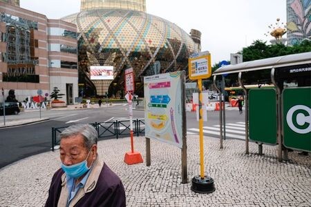 　マカオは今月２０日からカジノの営業再開を認める。政府系放送局ＴＤＭが１７日、当局者の話として報じた。写真は営業を停止しているカジノ「グランド・リスボア」の前を歩く男性。５日撮影（２０２０年　ロイター/Tyrone Siu）