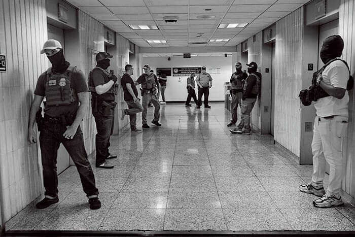 エレベーターホールで待機する捜査官たち。さながら待ち伏せ攻撃の場と化している