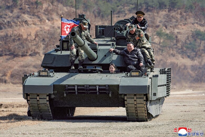 軍事訓練で戦車に乗る金正恩とジュエ（26年3月）　KCNAｰREUTERS