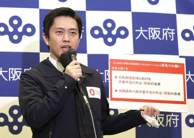 大阪府の吉村知事は、まん延防止等重点措置を実施してから2週間経っても医療提供体制が極めて厳しい状況となっているなどとして緊急事態宣言を国に要請すべきだと述べた。大阪府の新型コロナウイルス対策本部会議後、取材に応じる吉村知事、14日撮影（2021年　時事通信）