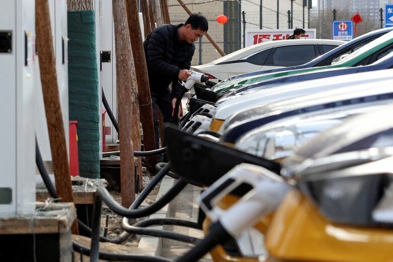 2024年2月2日、北京で車を充電する男性。 REUTERS/Florence Lo