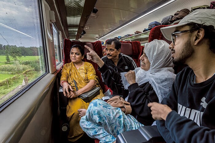 座席を窓側に向けて車窓の風景を楽しむ母と息子