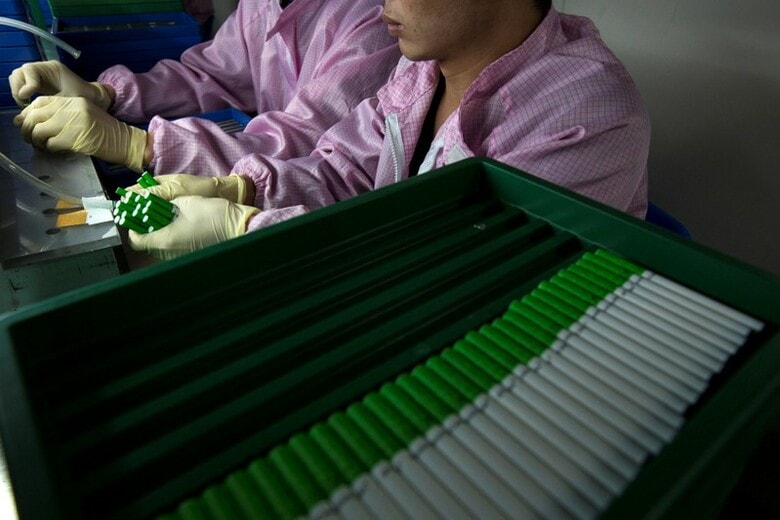 ６月２５日、トランプ米政権による中国製品に対する輸入関税は、米国の消費者を直撃しない製品を標的にしているが、実際にはグーグル傘下「ネスト」のサーモスタット（写真）やロックバンドが使う音響効果機器など、意外な製品も含まれるようだ。写真は中国・深センの電子タバコ工場。２０１４年撮影（２０１８年　ロイター/Tyrone Siu）