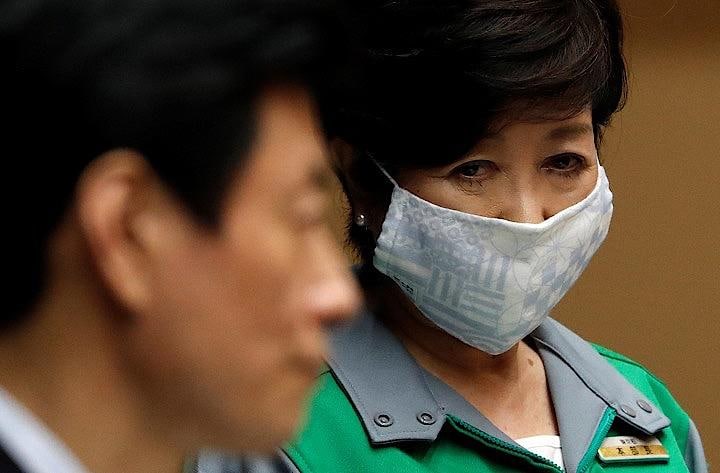 菅長官が週末に都内感染者の増加は「圧倒的に東京問題と言っても過言ではない」と発言したことに関し、圧倒的に検査数が多いのが東京で、なかには無症状の人が含まれていると指摘した。　写真は10日、西村再生相らとの記者会見での小池都知事　REUTERS/Issei Kato