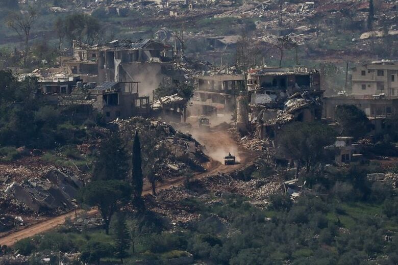 破壊されたレバノンの建物付近を通過するイスラエルの軍用車両。イスラエル側から4月30日撮影。REUTERS/Shir Torem