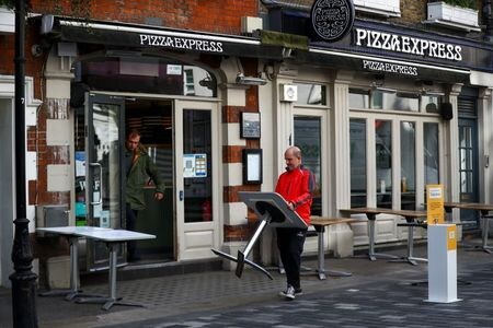 英国で４月１２日から、店舗や美容室、ジム、パブの営業が再開される。ジョンソン首相は、新型コロナウイルス感染拡大で実施した規制からの解放に向けた「重要な一歩」としている。写真はロンドンで９日、営業再開の準備をする飲食店関係者（２０２１年　ロイター/Hannah McKay）
