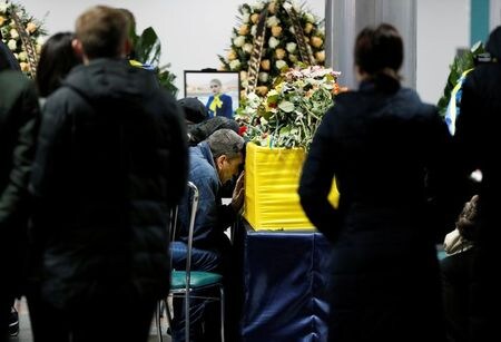 　１月１９日、ウクライナ旅客機撃墜を巡り、イランの航空当局者は回収した墜落機のブラックボックスはイランでの解析を目指す考えを示し、ウクライナに引き渡す決定が下されたとの報道を否定した。犠牲者を悼む人々、ウクライナのボルィースピリ国際空港で撮影（２０２０年　ロイター／Gleb Garanich）