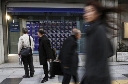 　１２月２５日、前場の東京株式市場で、日経平均株価は前営業日比１４円８７銭安の２万２８８７円８９銭となり、小反落した。写真は都内にある証券会社の株価ボード前で２０１５年２月撮影（２０１７年　ロイター／Toru Hanai）
