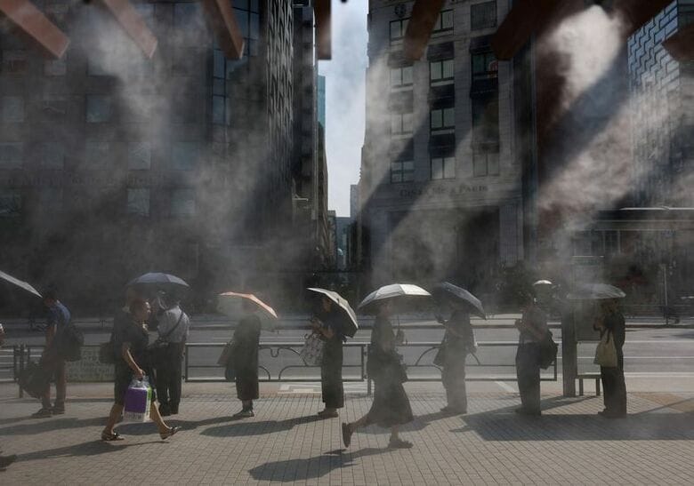 2025年7月9日、都内で日傘をさす人々。REUTERS/Issei Kato